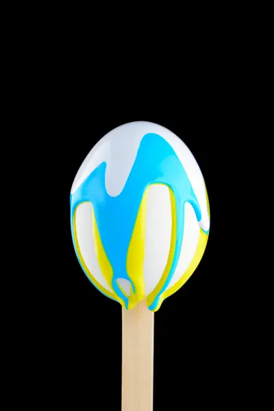 Egg on a wooden stick drenched colors — Stock Photo, Image