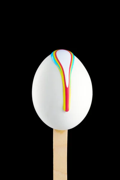 Egg on a wooden stick drenched colors — Stock Photo, Image