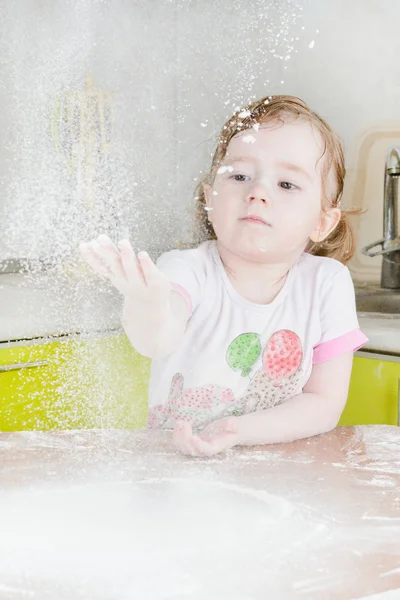 Little girl sifts flour — Stock Photo, Image