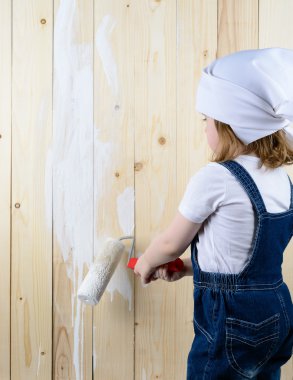 Küçük kız bir ahşap duvar boyaları