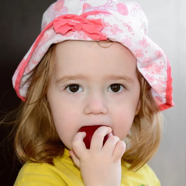 Портрет - маленькая девочка ест спелый нектарин — стоковое фото