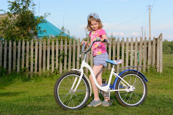 Маленькая девочка и велосипед — стоковое фото