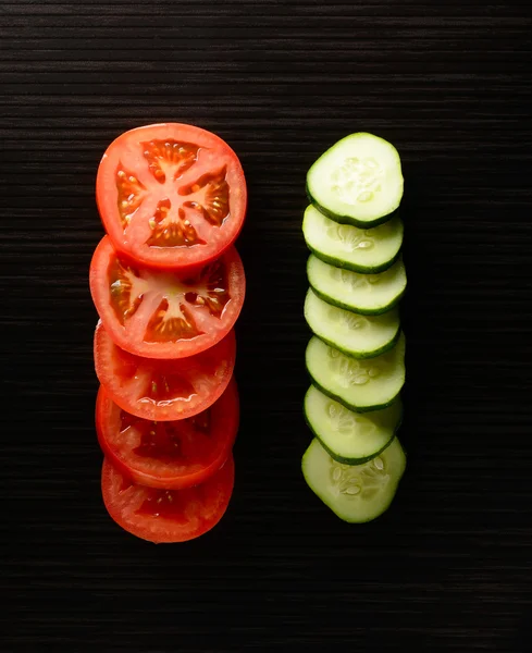 Cut tomato and cucumber with a knife — Stock Photo, Image