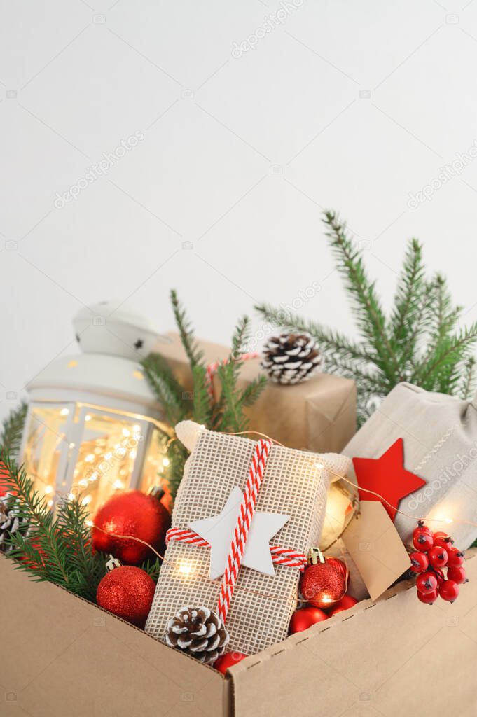 Christmas gifts in eco-friendly reusable packaging and decorations in a cardboard box. Delivery and donation concept.