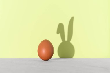 Yumurtalı paskalya asgari konsepti ve yeşil arka planda tavşan kulağı gölgesi. Yaratıcı komik tatil geçmişi. Boşluğu kopyala