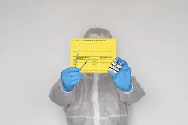 Trabajador Médico Con Traje Protector Con Tarjeta Registro Vacunación Amarilla —  Fotos de Stock