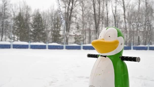 Apoyo de los niños para enseñar patinaje sobre hielo en un parque de la ciudad durante una nevada — Vídeos de Stock