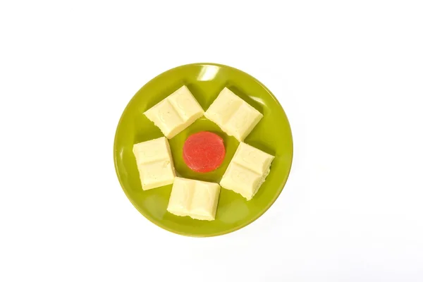 Green plate white chocolate red jujube — Stock Photo, Image