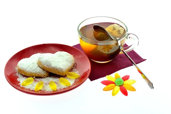 Biscotti su un disco rosso e una tazza di tè nero — Foto Stock