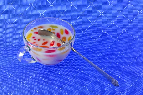 色とりどりのマーマレードとスプーンでミルクのカップ — ストック写真