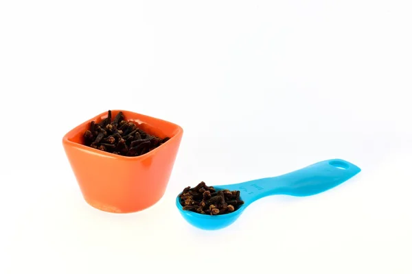 Clavo de especias en una taza y cuchara dosificadora —  Fotos de Stock