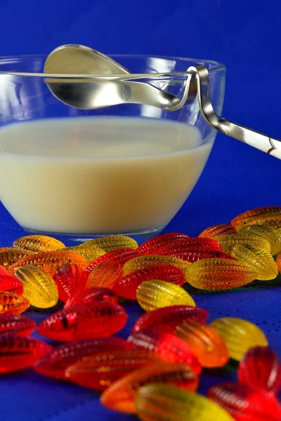Marmellata multicolore e una tazza di latte con cucchiaio — Foto Stock