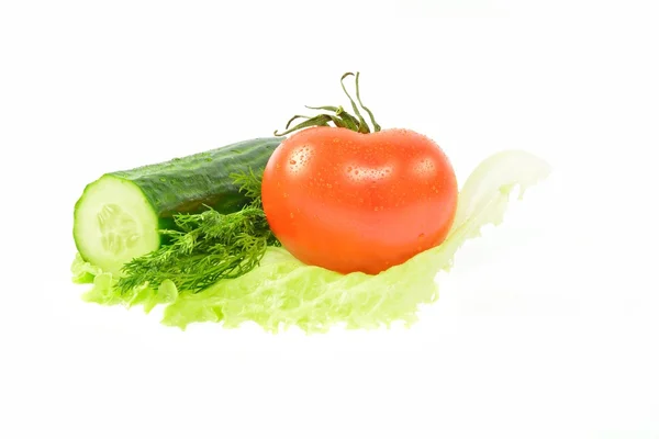 Полуогурец, помидор, укроп на куске салата — стоковое фото