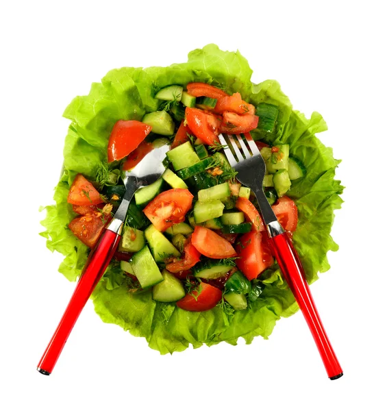 Salad of tomatoes, cucumbers and dill on lettuce leaves with a spoon and fork — Stock Photo, Image