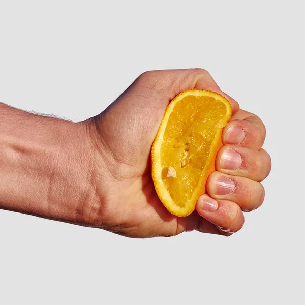 Man's hand squeezes the juice from the orange — Stock Photo, Image