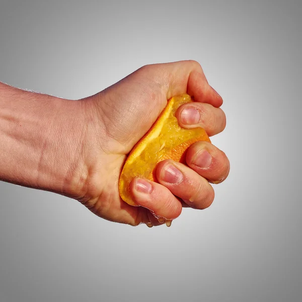 Férfi kezét összenyomja a lé a narancs — Stock Fotó