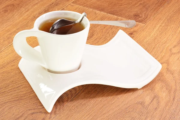 Schwarzer Tee in einer weißen Tasse und einem Löffel — Stockfoto