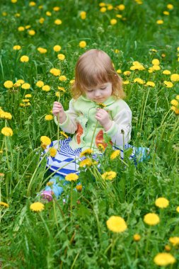 Küçük kız parkta yürüyor.