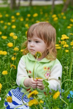 Küçük kız parkta yürüyor.