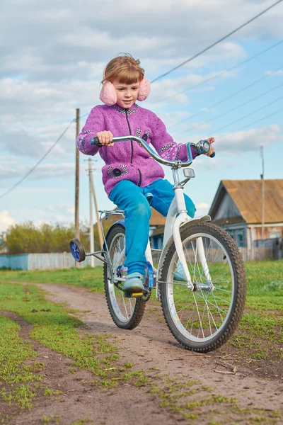 Ragazza in bicicletta nel villaggio — Foto Stock