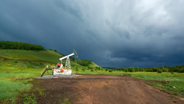 Koyu mavi fırtına bulutların üstünde Petrol pompalama için birim pompa — Stok fotoğraf