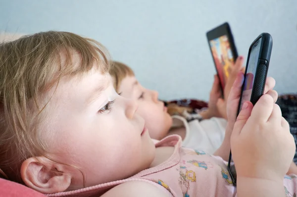 telefon ile oynayan iki kız