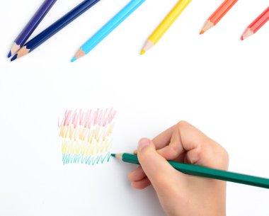 Kız bir gökkuşağı renkli kalemler boyalar