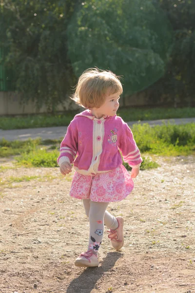 La bambina in giacca rosa corre — Foto Stock