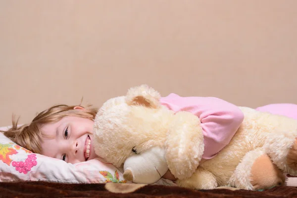 Fille couchée sur le lit avec un ours en peluche — Photo