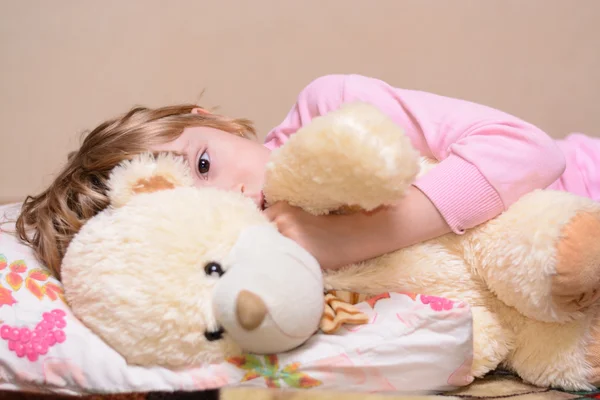 Fille couchée sur le lit avec un ours en peluche — Photo