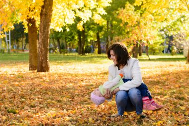 Parkta sarılma bir bebek ile anne
