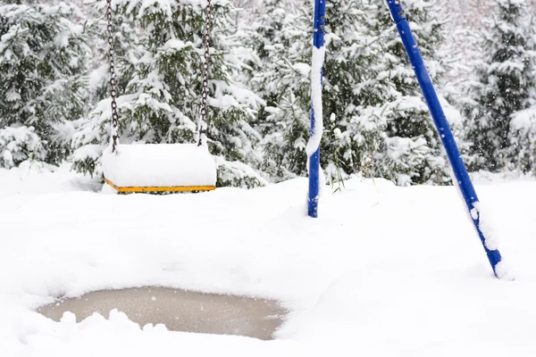 Schommel voor kinderen in de sneeuw — Stockfoto