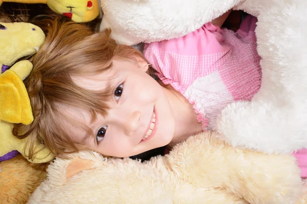 Niña se encuentra entre peluches — Foto de Stock