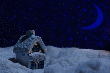 Oyuncak ev karda yün gece boyunca duruyor.