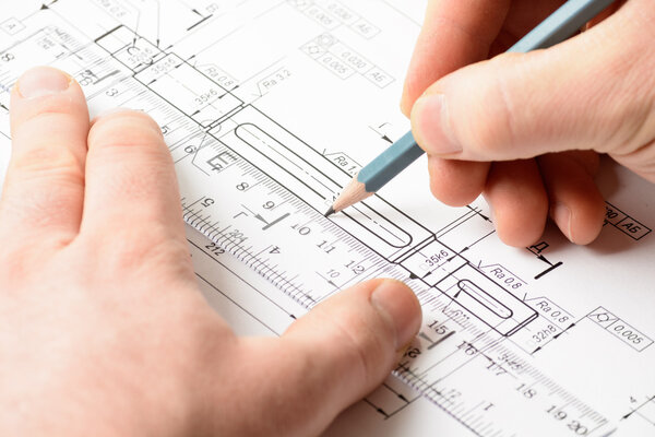 Мужская рука держит карандаш на рисунке
