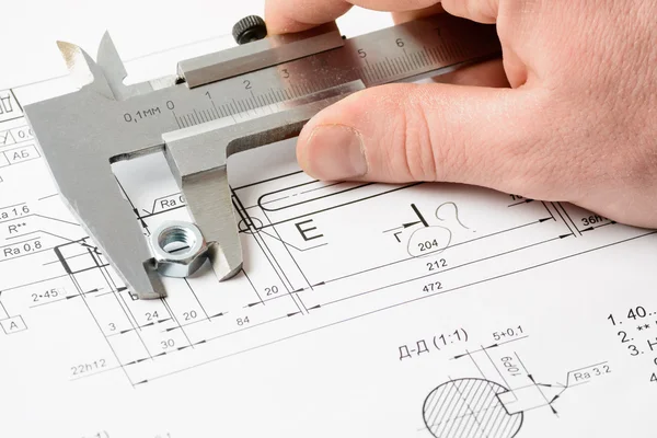 男の手が図面上ナットを測定 — ストック写真