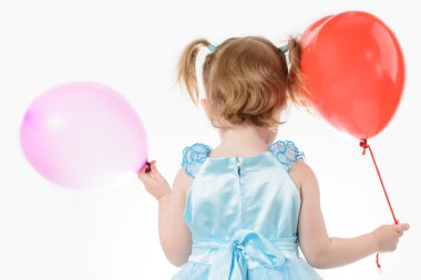 Bir balon tutan mavi elbiseli küçük kız