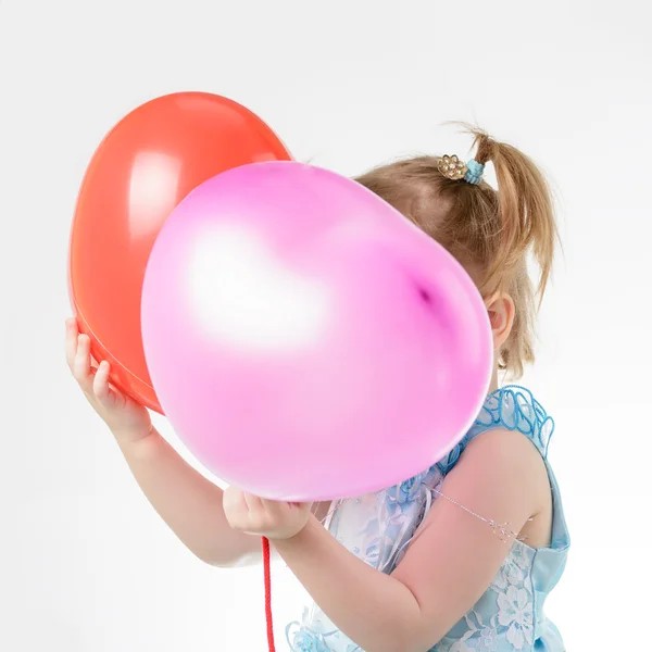 Petite fille en robe bleue tenant un ballon — Photo