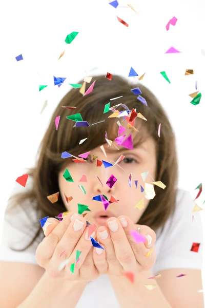 Young woman blows confetti with palms — Stock Photo, Image