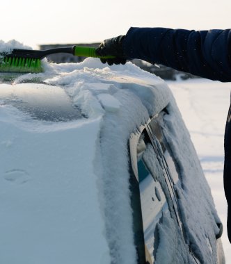 Genç adam araba kar temizler