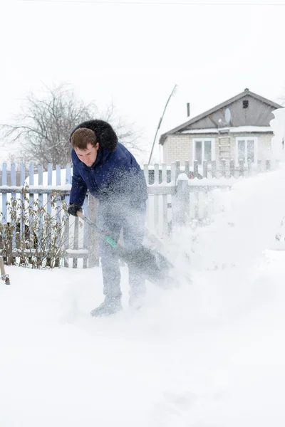 El joven despeja la nieve en el patio —  Fotos de Stock