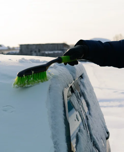 Joven limpia la nieve del coche —  Fotos de Stock