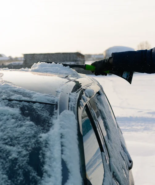 Jongeman reinigt sneeuw uit auto — Stockfoto