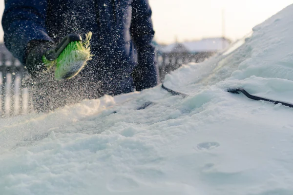 Joven limpia la nieve del coche —  Fotos de Stock