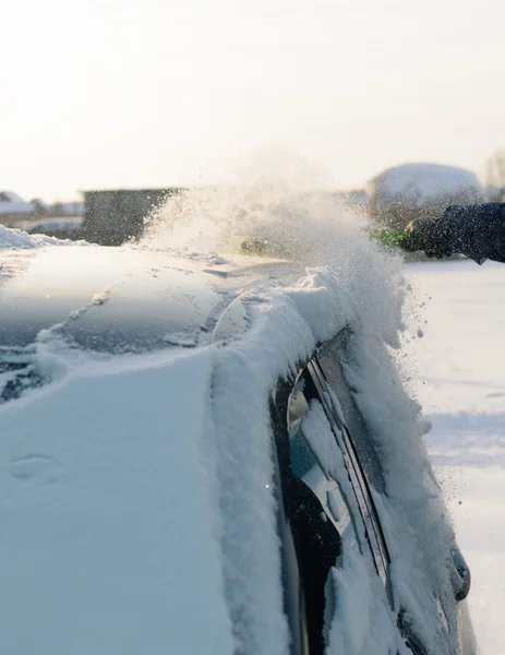 Giovane uomo pulisce la neve dalla macchina — Foto Stock