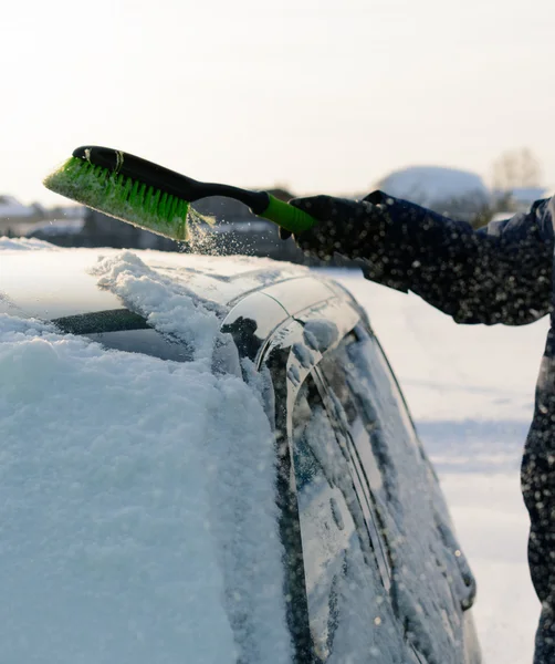 Giovane uomo pulisce la neve dalla macchina — Foto Stock