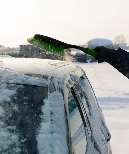 Jovem limpa a neve do carro — Fotografia de Stock