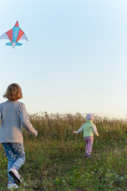 Bir uçurtma ile oynayan kızlar