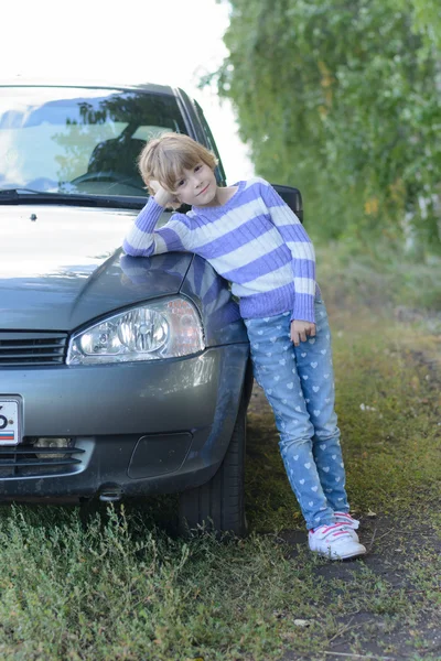 Das Mädchen in Jeans neben dem Auto — Stockfoto