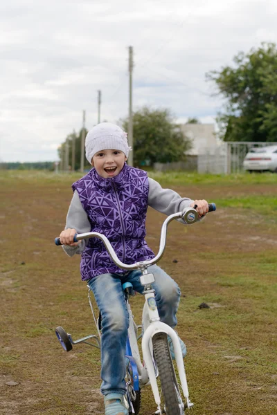 Ragazza in un gilet viola e jeans cavalca la sua moto — Foto Stock